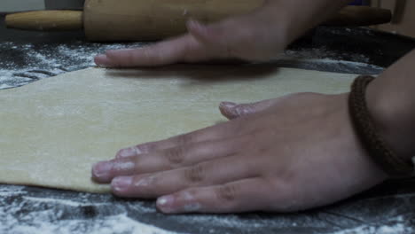 Female-Hands-Kneading-And-Flattening-Dough-On-Table
