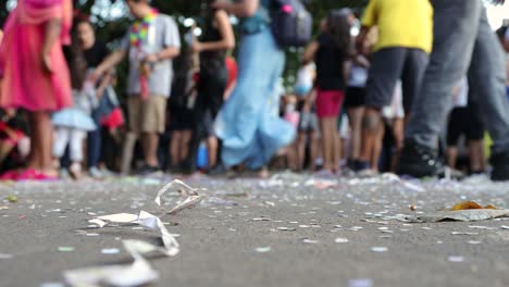 Street-Carnival-with-confetti-and-paper-on-the-ground-with-a-group-of-older-and-younger-people-blurry-in-the-background