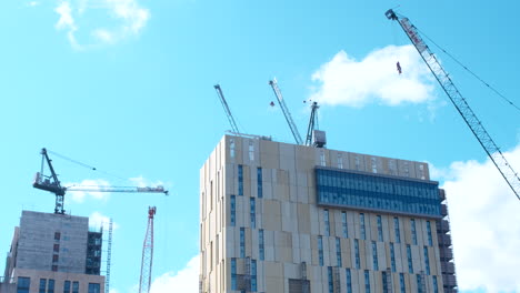 Low-angle-shot-of-cranes-and-construction-on-top-of-building,-Woking-Surrey