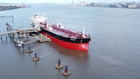 Aerial-industrial-crude-oil-tanker-ship-loading-at-petrochemical-refinery-terminal-rising-pull-away