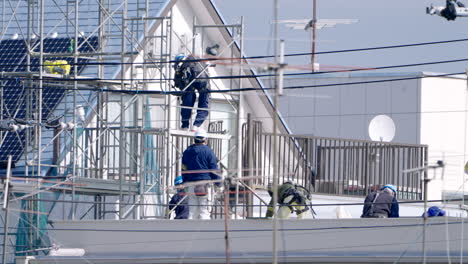 Construction-Workers-On-Scaffoldings-Working-With-Safety-Gears-Amidst-Pandemic-In-Tokyo,-Japan