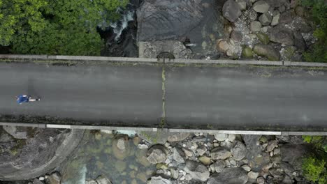 Mann-Läuft-über-Brücke-Auf-Der-Japanischen-Insel-Yakushima,-Luftaufnahme-Von-Oben-Nach-Unten