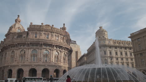 Piazza-de-Ferrari-square-in-Genova,-people,-fountain-and-Palazzo-della-Borsa-palace-at-sunny-day
