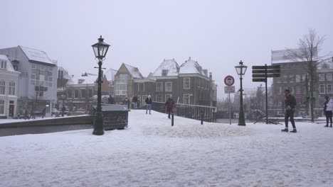 Locals-crossing-Catharinabrug-Catharina-Bridge,-Leiden-winter-snow-Netherlands