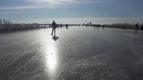 People-ice-skating-on-Dutch-frozen-canal-in-winter
