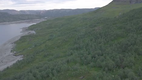 Aerial-view-of-high-voltage-towers-over-a-forest-in-Norway