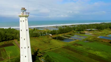 Aerial-dolly-revealing-lighthouse-on-Ketawang-beach-in-Purworejo-Indonesia