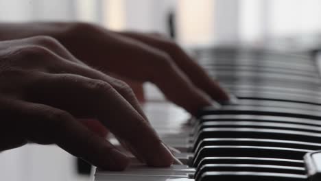 Piano-keyboard-with-extreme-close-up-of-hands-against-a-backlit-background-with-natural-color-and-selective-focus