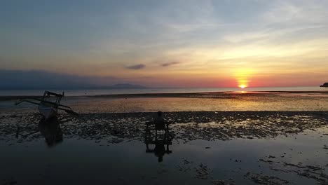 Man-on-bench-by-ocean-watching-water-reflecting-pastel-sunset-subtle-glow