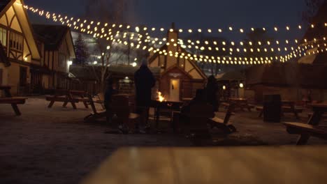 Ski-Resort-Family-Relaxes-Around-Cozy-Fire-Under-Winter-Lights