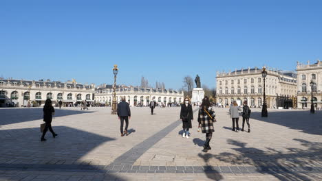 People-with-face-masks-walking-at-Place-Stanislas-on-sunny-day