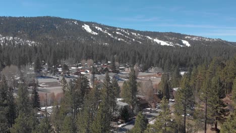Drone-shot-over-Big-Bear-California-trees-with-a-snow
