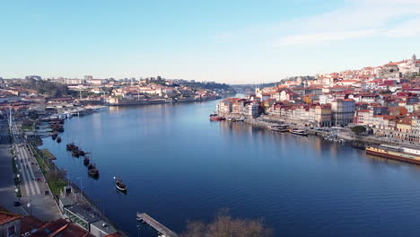Aerial-view-of-Douro-river,-Gaia-and-Porto-river-banks-on-a-sunny-day,-drone-going-forward