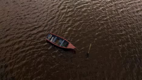 4K-aerial-view-of-an-old-fishing-boat-anchored-in-the-middle-of-the-Ria-de-Aveiro,-estuary-of-river-Vouga,-drone-steady-over-the-boat,-60fps