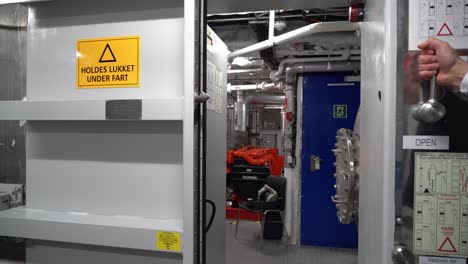Hand-grabs-the-knob-to-close-Automatic-watertight-door-inside-machinery-room-of-ship