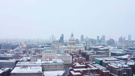 descending-aerial-drone-shot-of-St-Pauls-cathedral-snowing-City-of-London