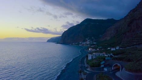 Beautiful-Sunset-View-Over-The-Calm-Sea-In-Madalena-Do-Mar,-Madeira-Island,-Portugal---Blue-Hour---aerial-drone,-pullback-shot