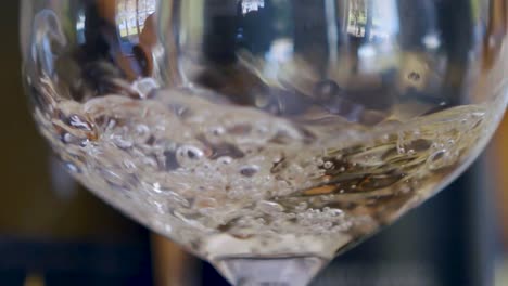 Slow-motion-pour-of-white-wine-into-a-glass-producing-lots-of-bubbles