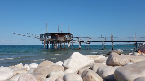Tourists-at-costa-dei-trabocchi-beach-with-trabocco-or-trabucco-in-background