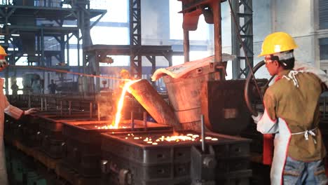 Foundry-worker-pouring-hot-metal-into-cast
