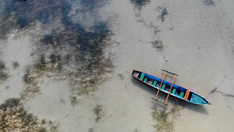 Local-fishing-boat-sits-empty-in-shallow-water-off-Saint-Marie,-Madagascar