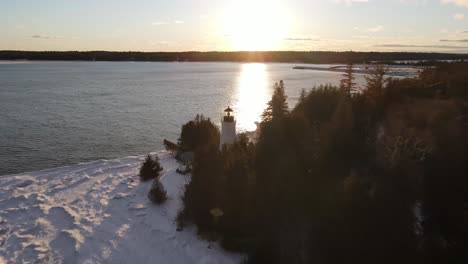 Old-Presque-Isle-Lighthouse-in-Michigan-during-the-winter-with-a-sunset