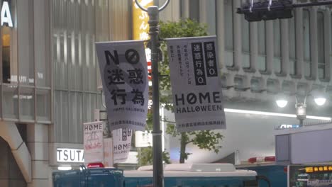 Banner,-Das-Die-Menschen-Auffordert,-In-Der-Halloween-Nacht-Zu-Hause-Zu-Bleiben,-Hängt-An-Einer-Stange-Am-Shibuya-Kreuzung-–-Covid-19-Pandemie-–-Mittlere-Aufnahme