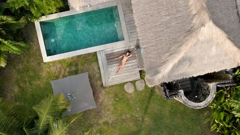 Mädchen-Liegt-Und-Ruht-Sich-Während-Des-Urlaubs-Auf-Gili-Air,-Indonesien,-Auf-Der-Terrasse-Einer-Luxusvilla-Mit-Pool-Aus