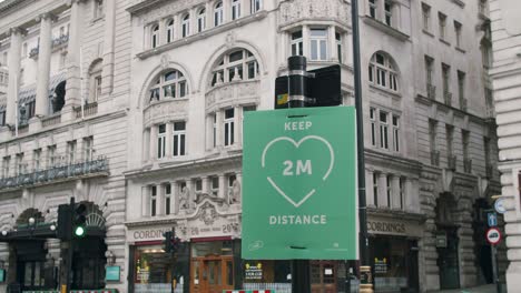 Sperrung-In-London,-Nahaufnahme-In-Zeitlupe-Mit-Dem-Schild-„Zwei-Meter-Abstand-Halten“-Auf-Leeren-Piccadilly-Straßen,-Während-Der-Coronavirus-Pandemie-2020