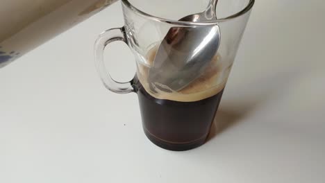 Transparentes-Glas,-Zur-Hälfte-Mit-Schwarzem-Kaffee-Gefüllt