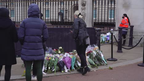 Buckingham-Palace-mourners-gather-and-look-at-flowers,-the-day-after-the-death-of-Prince-Philip,-Duke-of-Edinburgh,-Saturday-April-10th,-2021---London-UK