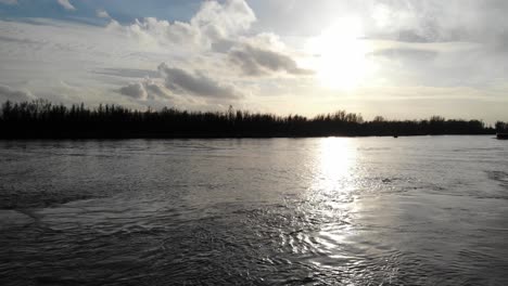 Sunlight-Reflects-Through-Quiet-Lake-During-Sunset-In-Oude-Maas-River-Near-Zwijndrecht,-Netherlands