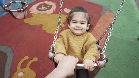 Gimbal-slow-motion-shot-of-baby-playing-with-his-father-on-swing-with-social-distance