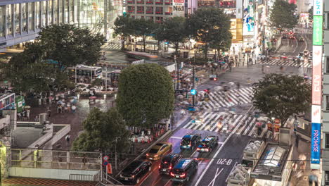 Passing-Train-At-JR-Shibuya-Station-With-Iconic-Intersection-Of-Shibuya-Crossing-In-Tokyo,-Japan