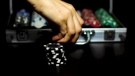 Eine-Hand-Nimmt-Gestapelte-Chips-Vom-Tisch-Auf,-Um-Sie-In-Eine-Poker-Aktentasche-Zu-Stecken