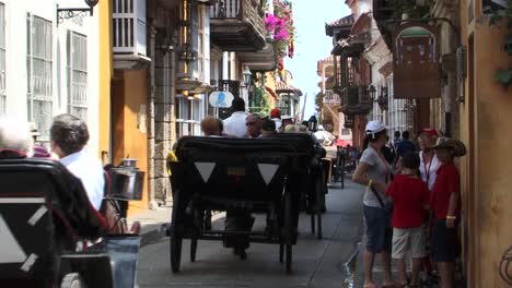 Touristen-Besuchen-Die-Altstadt-Von-Cartagena,-Kolumbien-In-Pferdekutschen