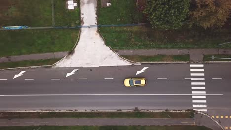 Aerial-top-view-of-a-yellow-Opel-Insignia-car-on-a-city-road