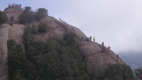 Tourists-climb-stairs-to-top-of-Montserrat-mountain,-Spain