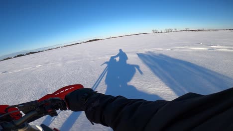 Snowbike-POV-Super-Slomo-Schnee,-Der-Hinter-Dem-Fahrer-Hochfliegt,-Wie-Im-Schatten-Des-Sonnenuntergangs-Zu-Sehen-Ist