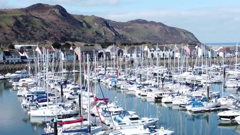 Luxury-yachts-and-sailboats-moored-in-Conwy-marina-mountain-waterfront-aerial-view-North-Wales-close-rising-right