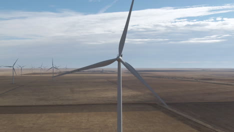 Static-aerial-of-spinning-wind-turbine-in-north-Texas,-USA-with-other-turbines-spinning-in-the-background