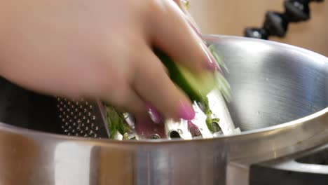 Female-hands-grating-fresh-cucumber-in-static-view