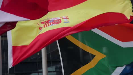 Slow-motion-national-flags-of-Spain,-South-Africa,-Switzerland,-and-Saudi-Arabia-are-seen-waving-in-the-wind-in-Hong-Kong