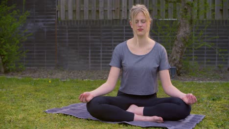 Eine-Junge-Frau-Macht-Yoga-Im-Hinterhof