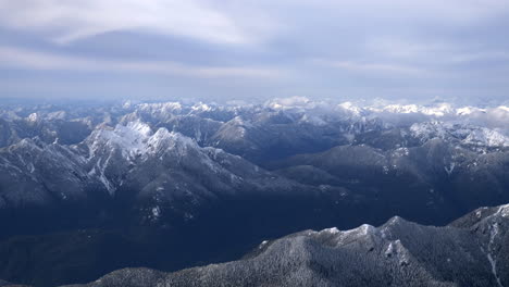 Aerial-shot-of-snow-capped-mountains-on-cloudy-day