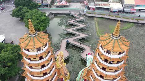 Descending-tilting-view-from-the-back-of-the-Spectacular-Dragon-And-Tiger-Pagodas-Temple-With-Seven-Story-Tiered-Tower-Located-at-Lotus-Lake-at-Kaohsiung-Taiwan
