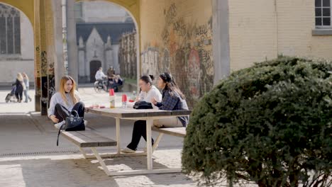 Fun-young-girls-gossiping-and-sharing-secrets-in-an-urban-religious-location---slow-motion