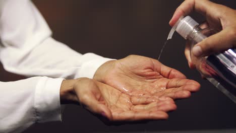 Woman-sanitizing-her-hands-with-gel---close-up-isolated