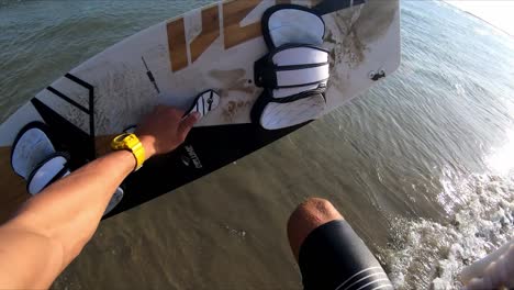 POV-man-picks-up-kitesurfing-board-sand-runs-into-water-jump-sunny-summer-day