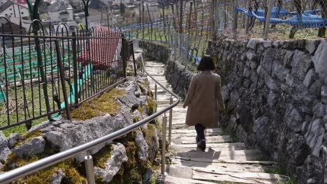 Junge-Asiatische-Frau,-Die-Auf-Einem-Wanderweg-In-Der-Schweiz-Eine-Lange-Treppe-Hinuntergeht